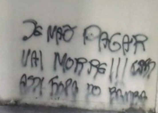 “Se não pagar vai morrer”. Pichação em muro de condomínio em Colégio reforça ameaças de traficantes do TCP que exigem pagamento de taxas. Chefão preso teria dado a ordem